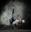 Photo: Young b-boy man doing brake dancing movements on skateboard Young b-boy man doing brake dancing movements on skateboard
