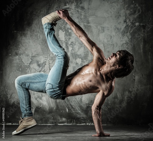 Photo: Young b-boy man with naked torso doing brake dancing movements Young b-boy man with naked torso doing brake dancing movements