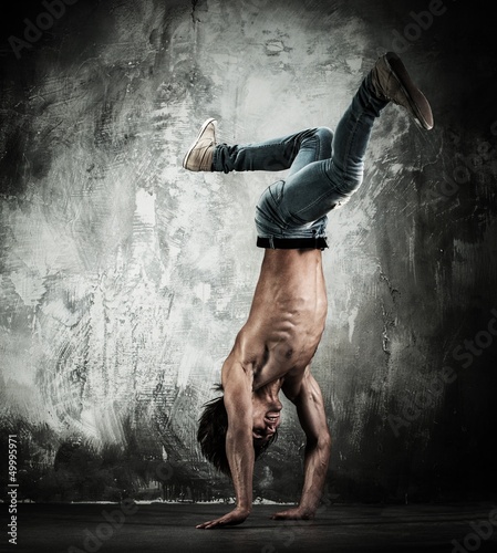 Photo: Young b-boy man with naked torso doing brake dancing movements Young b-boy man with naked torso doing brake dancing movements