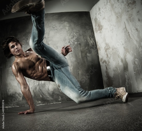 Photo: Young b-boy man with naked torso doing brake dancing movements Young b-boy man with naked torso doing brake dancing movements