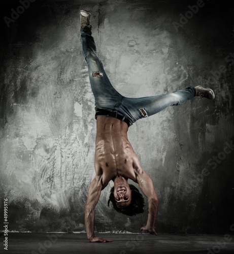 Photo: Young b-boy man with naked torso doing brake dancing movements Young b-boy man with naked torso doing brake dancing movements