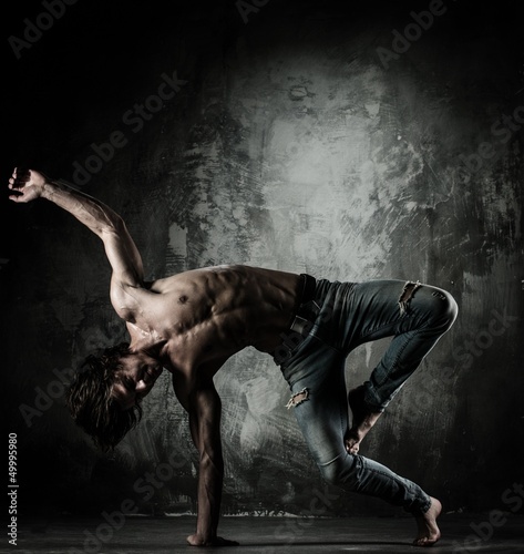 Photo: Young b-boy man with naked torso doing brake dancing movements Young b-boy man with naked torso doing brake dancing movements