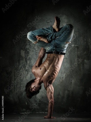 Photo: Young b-boy man with naked torso doing brake dancing movements Young b-boy man with naked torso doing brake dancing movements