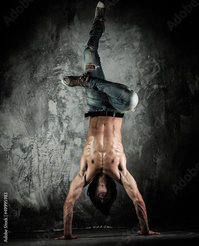 Photo: Young b-boy man with naked torso doing brake dancing movements Young b-boy man with naked torso doing brake dancing movements