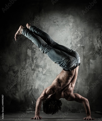 Photo: Young b-boy man with naked torso doing brake dancing movements Young b-boy man with naked torso doing brake dancing movements