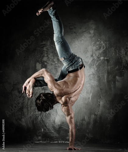 Photo: Young b-boy man with naked torso doing brake dancing movements Young b-boy man with naked torso doing brake dancing movements