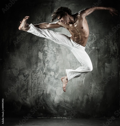 Photo: Young b-boy man with naked torso performing jumps Young b-boy man with naked torso performing jumps