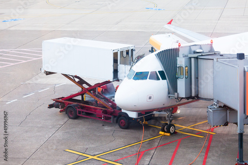 Photo: Plane on airport docked for boarding and service Plane on airport docked for boarding and service