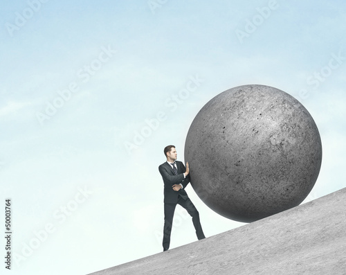 Photo: man pushing ball man pushing ball