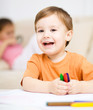 Little boy is drawing on white paper
