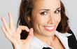 Happy business woman with okay gesture, over gray