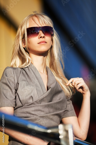 Photo: Blond woman in sunglasses against office windows Blond woman in sunglasses against office windows