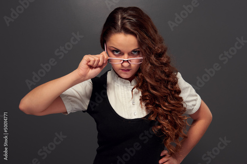 Photo: serious girl in formal wear and glasses serious girl in formal wear and glasses