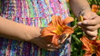 young pregnant woman sniffing flowers daylily