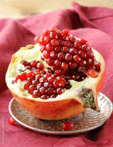 Photo: pomegranate ripe fruit on a silver plate pomegranate ripe fruit on a silver plate