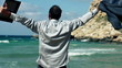 Businessman on the beach rising hands to the sky, slow motion sh