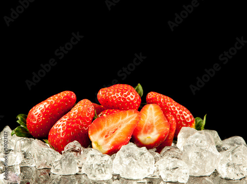 Photo: strawberry on black background. strawberries with ice cubes on strawberry on black background. strawberries with ice cubes on