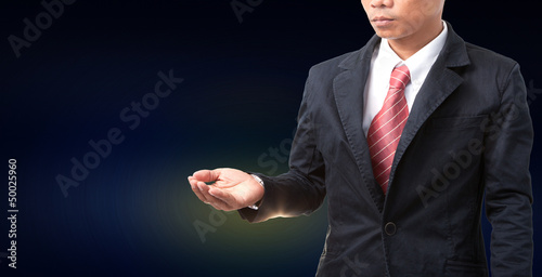 Photo: man wearing black suit post seem like holding something in hand man wearing black suit post seem like holding something in hand