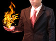 Photo: business man holding fire flaming on hand business man holding fire flaming on hand