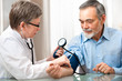 Foto: Doctor measuring blood pressure of male patient Doctor measuring blood pressure of male patient
