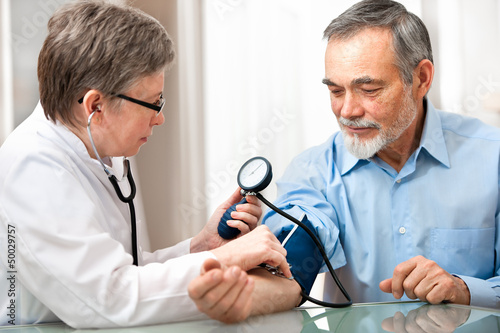 Photo: Doctor measuring blood pressure of male patient Doctor measuring blood pressure of male patient