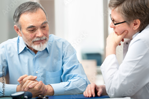 Photo: Doctor talking to her male patient at office Doctor talking to her male patient at office