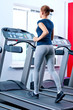 Young woman at the gym run on on a machine