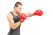 Male boxer punching with red boxing gloves