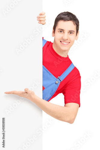 Photo: A smiling repairman showing on a blank panel A smiling repairman showing on a blank panel