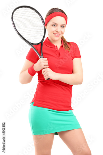 Photo: A young female posing with a tennis racket A young female posing with a tennis racket