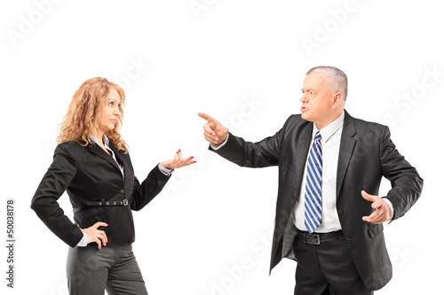 Photo: Mature man in a suit having a disagreement with a businesswoman Mature man in a suit having a disagreement with a businesswoman