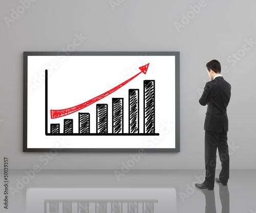 Photo: man looking at growth chart man looking at growth chart