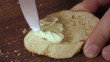 hand spreading butter on bread 