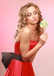 young happy woman with lollipop, isolated on pink background