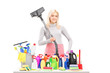 Young smiling woman with a hover and cleaning supplies on a tabl