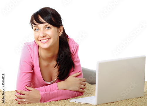 Photo: A young girl with a laptop lying on the floor A young girl with a laptop lying on the floor
