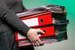 Photo: Female office worker carrying a stack of files Female office worker carrying a stack of files