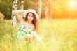 Photo: Young redhead woman in the park with flowers Young redhead woman in the park with flowers