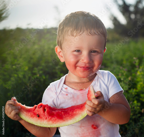 Photo: little baby eating watermelon outdoors little baby eating watermelon outdoors