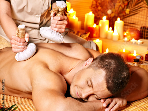 Photo: Man getting herbal ball massage treatments . Man getting herbal ball massage treatments .