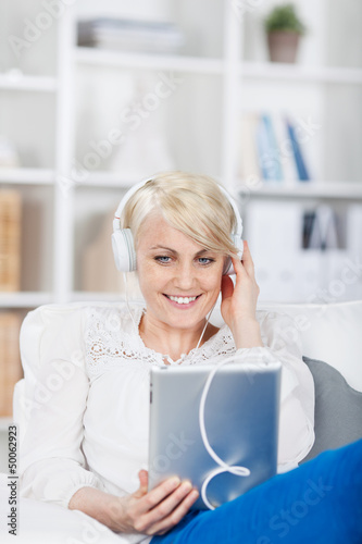 Photo: junge frau hört musik mit ihrem tablet junge frau hört musik mit ihrem tablet