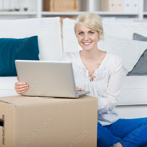 Photo: frau mit laptop und umzugskarton frau mit laptop und umzugskarton