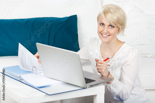 Photo: junge frau lernt mit laptop zu hause junge frau lernt mit laptop zu hause