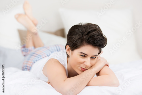 Photo: lächelnde frau liegt auf dem bett lächelnde frau liegt auf dem bett