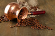 Coffee pot with coffee beans on wooden background