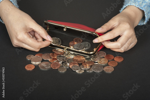 Photo: Woman's hand handling money in a purse Woman's hand handling money in a purse