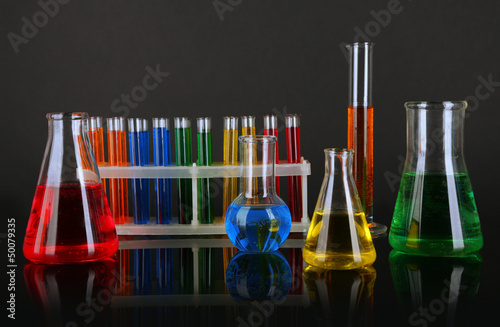 Photo: Test tubes with colorful liquids on dark grey background Test tubes with colorful liquids on dark grey background