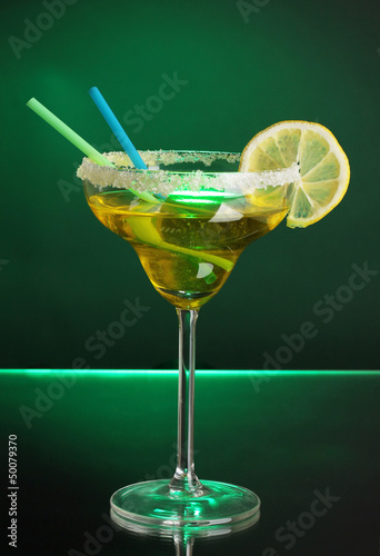 Photo: Yellow cocktail in glass on color background Yellow cocktail in glass on color background