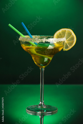 Photo: Yellow cocktail in glass on color background Yellow cocktail in glass on color background