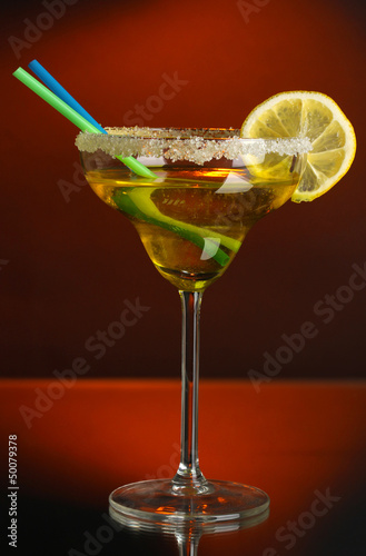 Photo: Yellow cocktail in glass on color background Yellow cocktail in glass on color background